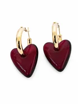 Aros con argolla metálica dorada y colgante en forma de corazón de resina translúcida color bordó.