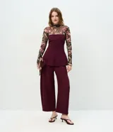 Pantalón de sastrería color bordó, con modelaje barrel, cintura estructurada, pasadores para cinturón y piernas amplias con ruedo levemente afinado.