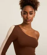 Blusa deportiva de microfibra color marrón, con escote asimétrico de un solo hombro y manga larga con recorte contrastante color beige.