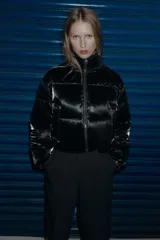 Anorak acolchado de efecto brillante con tejido cortavientos y repelente al agua. Presenta cuello subido, cierre frontal con cremallera, bolsillos delanteros con forro polar y cierre de cremallera, y mangas largas con puños elásticos. El bajo es ajustable con cordones elásticos laterales.