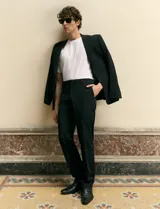 Ambo slim fit negro confeccionado en tejido tecnológico elastizado, compuesto por blazer estructurado y pantalón de vestir de corte recto.