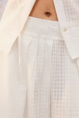 Pantalón amplio de largo maxi, color negro, con piernas anchas, cintura elástica fruncida y diseño de tela liviana con textura calada transparente.