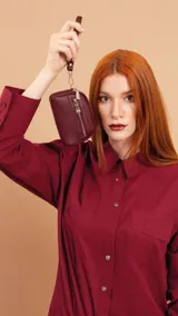 Monedero de dama con correa de mano, confeccionado en material símil cuero con textura granulada. Cuenta con doble compartimento principal con cierre y un bolsillo frontal con cierre, ideal para organizar tarjetas, billetes y monedas.