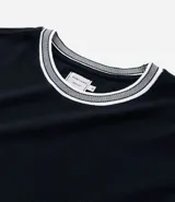 Remera de corte regular confeccionada en tejido texturizado de algodón y poliéster. Presenta cuello redondo y bordes de mangas con detalle de rayas contrastantes en blanco y gris.