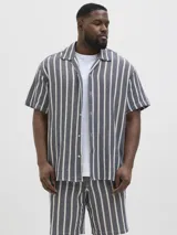 Camisa de manga corta con cuello resort y fit regular. Tejido plano de sarga con textura suave y caída ligera. Cierre frontal con botones.