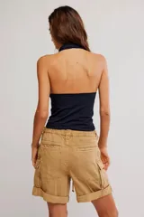 Top negro sin mangas, con escote halter profundo y diseño ajustado al cuerpo.