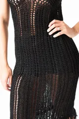 Vestido negro de algodón con breteles finos, corte ajustado al cuerpo y largo midi con flecos en el ruedo.