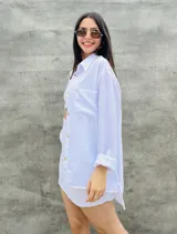 Conjunto blanco de camisa de manga larga con botones y shorts con bolsillos.