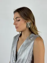 Aros circulares plateados con textura ondulada.