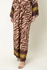 Pantalón palazzo de viscosa con estampado de cebra en tonos azul marino y beige, con detalles en marrón en la cintura y el ruedo.