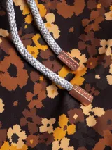 Short de baño con estampado floral en tonos marrones y amarillos, con cordón ajustable en la cintura, bolsillos laterales y trasero con cierre, y suspensor de malla fina hipoalergénico.
