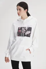 Buzo hoodie blanco de calce holgado con estampado de rosas y logo de Levi's en el pecho.
