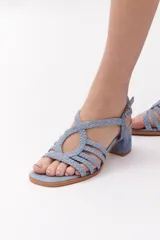 Sandalia de mujer color terracota/rojo oscuro, con taco ancho y tiras trenzadas que cubren el empeine. Posee tira ajustable con hebilla en el tobillo.