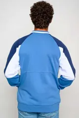 Campera bomber Umbro del Club Nacional de Football, color azul marino con diseño tricolor en las mangas con rojo y blanco, cuello tipo rib con rayas, y cierre frontal completo.