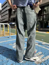 Jean de corte baggy con diseño de paneles laterales y costuras reforzadas, en tono gris lavado con efecto desgastado.