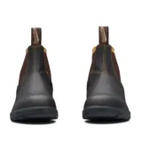 Botas tipo Chelsea Blundstone modelo 500, confeccionadas en cuero premium color marrón oscuro. Presentan elásticos laterales en tono marrón, tiradores en la parte superior y suela de TPU de alta durabilidad con tecnología de amortiguación en el talón.