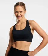 Top deportivo negro con textura acanalada, escote redondo y breteles anchos estilo nadador. Incluye copas removibles y forro interior.