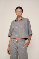 Camisa corta estilo denim color gris, de corte cuadrado, con mangas cortas y apliques brillantes en el frente y la espalda.