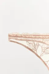 Tanga de tiro medio confeccionado en tejido mesh con bordados florales a tono y cintura elástica.