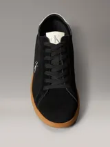 Zapatillas Calvin Klein de perfil bajo elaboradas en ante negro, con suela cupsole de goma marrón. Presentan detalles en contraste de color blanco en el talón y la lengüeta, además del monograma 'ck' bordado en el lateral.