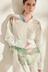 Camisa de lino italiano color crudo con estampado artístico de paisajes, cuello mao, manga larga, cierre frontal de botones y un bolsillo en el pecho.