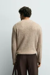 Jersey de punto con textura acanalada y efecto jaspeado, de corte regular, cuello redondo y manga larga con terminaciones en rib.