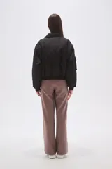 Campera tipo bomber color negro, con cierre frontal, cuello camisero, bolsillos frontales con solapa y puños elásticos.