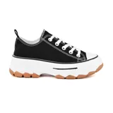 Championes de lona negra con plataforma blanca y suela dentada color caramelo. Presentan cordones blancos y costuras visibles en contraste.