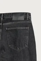 Jeans flare fit de denim negro, tiro medio, ajustados arriba y con botamanga acampanada. Cuentan con cinco bolsillos, lavado efecto gastado y bajo con acabado irregular. Cierre frontal con cremallera y botón.