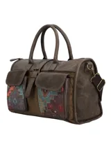 Cartera tipo bolso de mano y bandolera en color marrón, con diseño patchwork étnico en los bolsillos frontales. Cuenta con dos bolsillos exteriores con solapa y broche magnético, cierre principal con cremallera, manijas fijas y correa ajustable y removible. Incluye un llavero decorativo con borlas y dijes colgantes en el lateral.