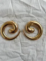 Aros grandes dorados con forma de espiral.