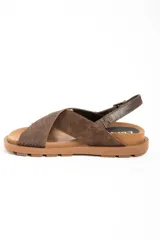 Sandalias de cuero color marrón con tiras cruzadas en el empeine, suela chunky texturizada y tira trasera ajustable con hebilla metálica.