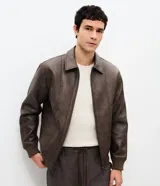 Campera de poliuretano con acabado lavado, diseño de corte regular, cuello camisero, cierre frontal, puños y cintura con rib elástico.