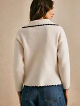 Sweater de punto color off white con cuello estilo sailor y detalles de borde festoneado en contraste negro en cuello, puños y ruedo. Presenta un diseño de manga larga y calce relajado.