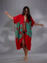 Capullo o kimono de paño 100% algodón, color rojo con estampado exclusivo en tono verde, de morfología amplia y envolvente, con bolsillos laterales y cinto independiente para ajustar la cintura.