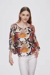 Blusa estampada con flores en tonos marrones, naranjas y negros, con mangas 3/4 acampanadas y cuello redondo.