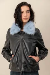 Campera de cuero negro con cuello desmontable de piel sintética en color celeste, cierre frontal y bolsillos laterales.