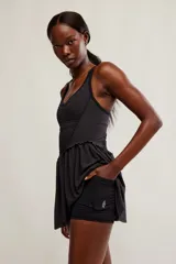 Vestido corto deportivo negro con efecto smock en el torso, tirantes finos blancos y falda de vuelo suave.