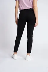 Pantalón de gabardina corte skinny, color beige, con diseño de cinco bolsillos, cierre de cremallera y botón frontal.