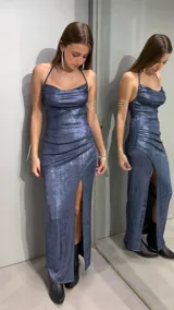 Vestido largo de fiesta azul con brillo, corte al cuerpo, escote halter y tajo lateral en la pierna.