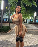 Vestido corto color dorado, con breteles finos, corte ajustado y falda con volados.