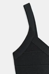 Vestido mini confeccionado en tejido elástico negro, con escote en pico y tirantes anchos.
