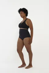 Soutien modelador negro de escote en V, sin costuras visibles, con tirantes anchos y banda inferior ancha para mayor soporte.