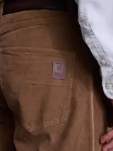Pantalón de pana color marrón, de corte recto y diseño clásico con bolsillos laterales y traseros.