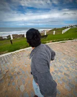 Buzo con medio cierre gris oscuro con efecto lavado stone wash, de corte oversized, mangas largas, cuello alto y bolsillo tipo canguro al frente con una pequeña etiqueta blanca con la marca.