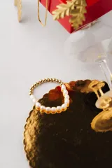 Pulsera elástica con cuentas de perlas blancas y cuentas doradas.
