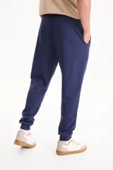 Pantalón de jogging negro sin friza, con puños elastizados en los tobillos y cordón ajustable en la cintura.