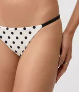 Bombacha de bikini colaless de microfibra color blanco con estampado integral de lunares negros y laterales finos contrastantes.