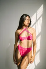 Conjunto de bikini fucsia aterciopelado, compuesto por un corpiño con aro y breteles regulables, y una bombacha colaless de tiro alto.