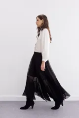 Falda larga de viscosa chiffon color negro, con diseño amplio y voluminoso. Presenta un ruedo irregular con volados que aportan movimiento y cintura elastizada para mayor comodidad. Incluye forrería interna a tono.